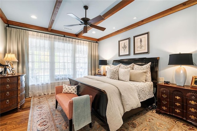 bedroom with ceiling fan, beam ceiling, and light hardwood / wood-style floors