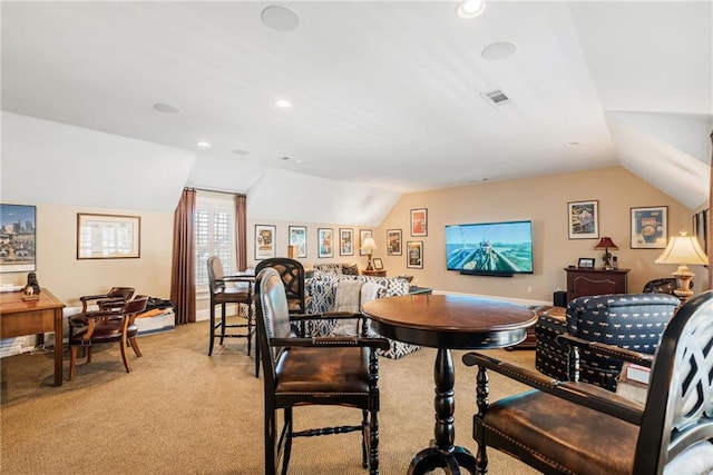 carpeted dining area featuring lofted ceiling