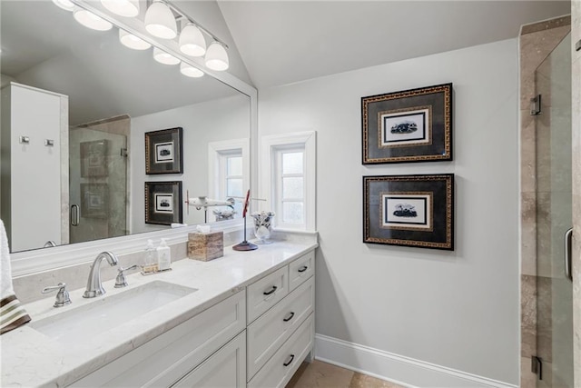 bathroom with vanity, a shower with shower door, and lofted ceiling