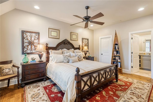 bedroom with ceiling fan, wood-type flooring, and connected bathroom