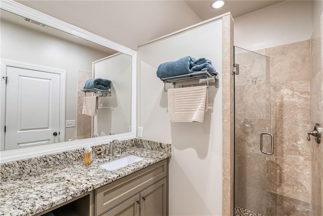 bathroom with vanity and a shower with door