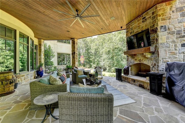 view of patio with ceiling fan and an outdoor living space with a fireplace