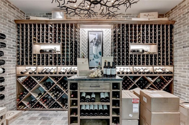 wine cellar featuring brick wall and a notable chandelier