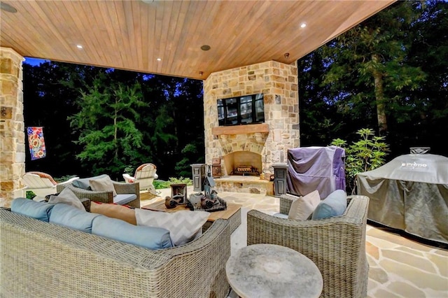 view of patio / terrace with grilling area and an outdoor living space with a fireplace