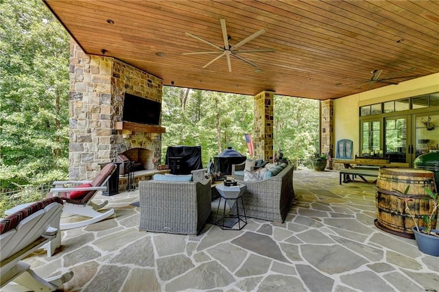 view of patio featuring ceiling fan, grilling area, and an outdoor living space with a fireplace