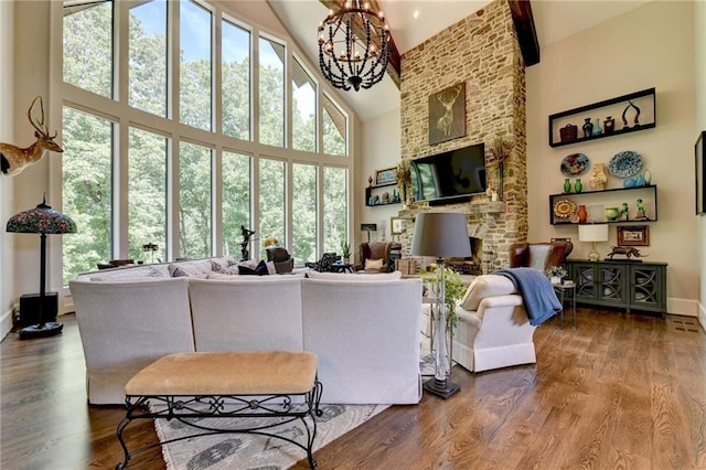 living room with hardwood / wood-style floors, an inviting chandelier, and high vaulted ceiling