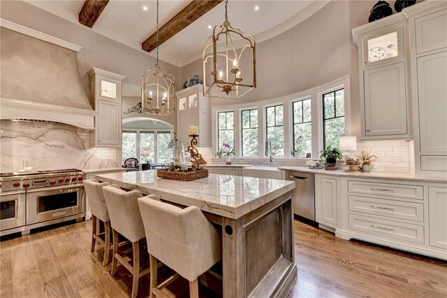 kitchen with white cabinetry, appliances with stainless steel finishes, a center island, and tasteful backsplash