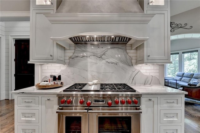 kitchen featuring premium range hood, double oven range, white cabinetry, and light stone counters