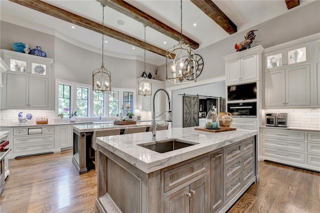 kitchen with decorative light fixtures, white cabinets, a spacious island, and a barn door