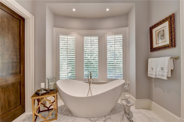 bathroom with a tub and plenty of natural light