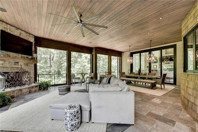 sunroom with wood ceiling, a healthy amount of sunlight, and a fireplace