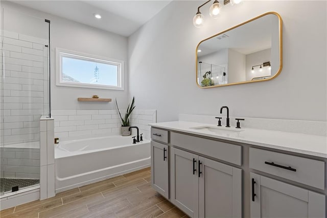 bathroom featuring vanity and shower with separate bathtub