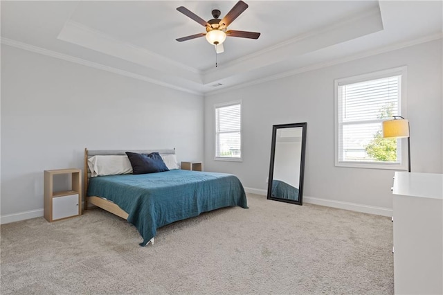 carpeted bedroom featuring a raised ceiling, ceiling fan, and crown molding