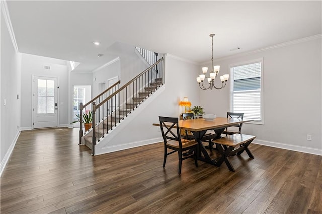 dining space featuring dark hardwood / wood-style flooring, ornamental molding, and a chandelier