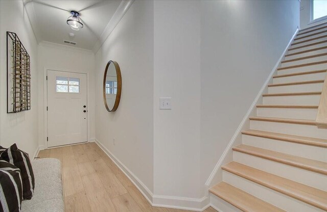 kitchen with decorative backsplash, white cabinets, ornamental molding, and appliances with stainless steel finishes