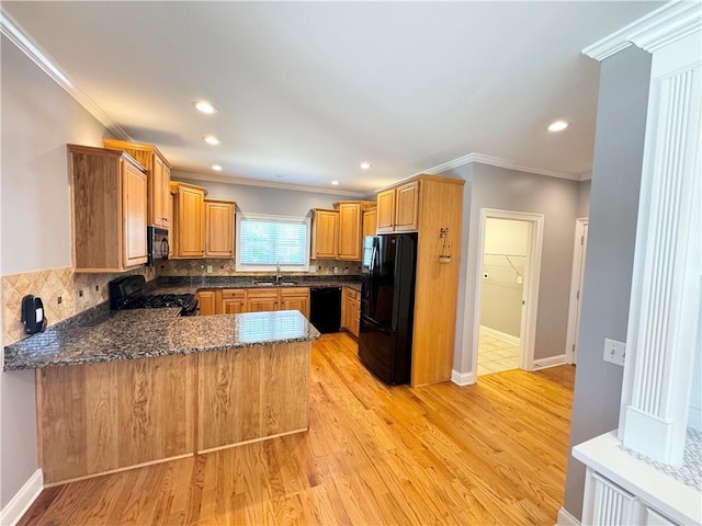 8967 Midlothian Ct, Winston, GA 30187 - kitchen with black appliances, a peninsula, a sink, ornamental molding, and light wood-style floors