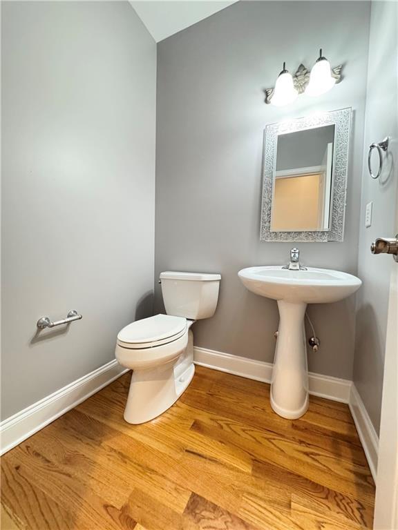 8967 Midlothian Ct, Winston, GA 30187 - bathroom with toilet, wood finished floors, and baseboards