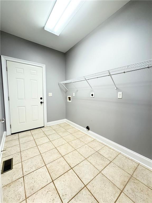 8967 Midlothian Ct, Winston, GA 30187 - laundry area with hookup for a washing machine, light tile patterned floors, hookup for an electric dryer, and baseboards