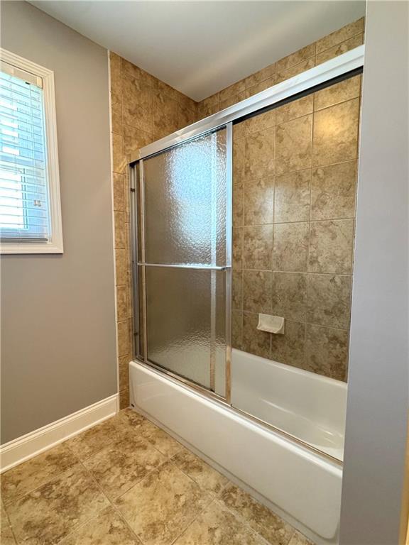 8967 Midlothian Ct, Winston, GA 30187 - bathroom with bath / shower combo with glass door and baseboards