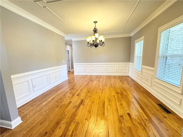 8967 Midlothian Ct, Winston, GA 30187 - unfurnished dining area with a chandelier, crown molding, light wood-style flooring, a wainscoted wall, and a decorative wall