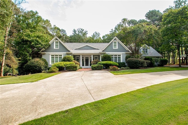 view of front of house with french doors, driveway, and a front lawn