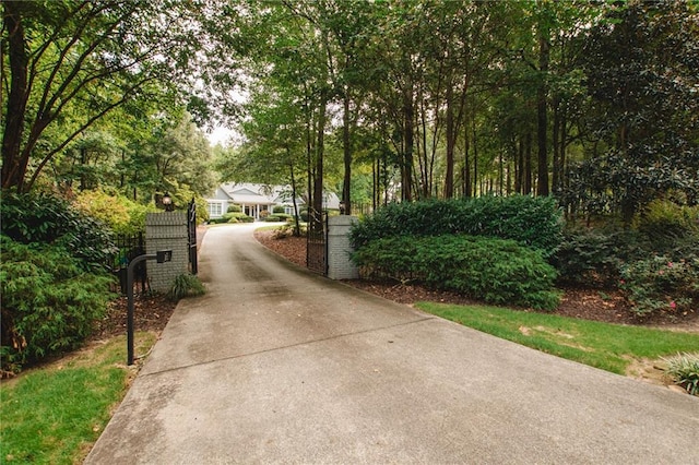 view of property's community featuring concrete driveway and fence