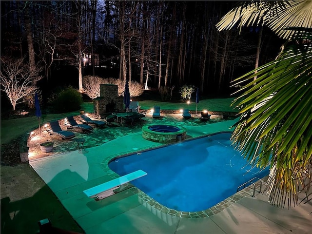 view of pool with a patio area, a fireplace, and a diving board