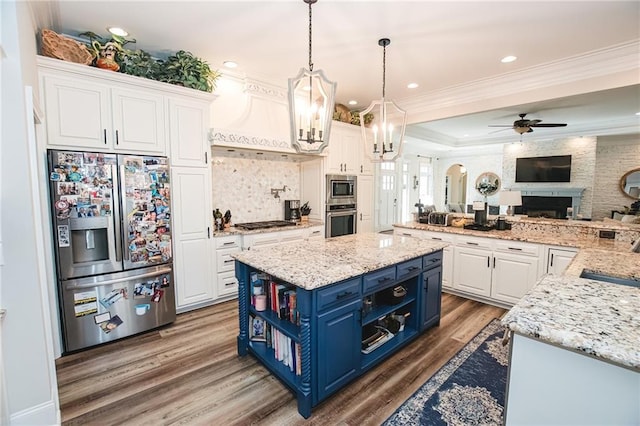 kitchen with crown molding, open floor plan, appliances with stainless steel finishes, white cabinetry, and blue cabinets