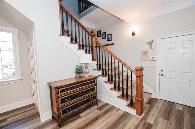 foyer entrance with stairs, crown molding, wood finished floors, and baseboards