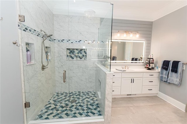 bathroom featuring a stall shower, vanity, crown molding, and baseboards