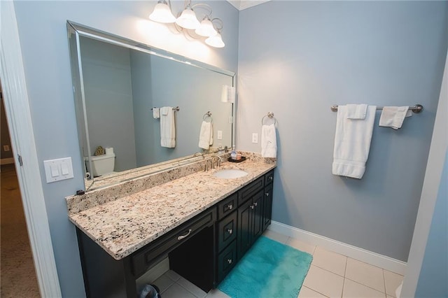 bathroom with tile patterned floors, an inviting chandelier, vanity, and baseboards