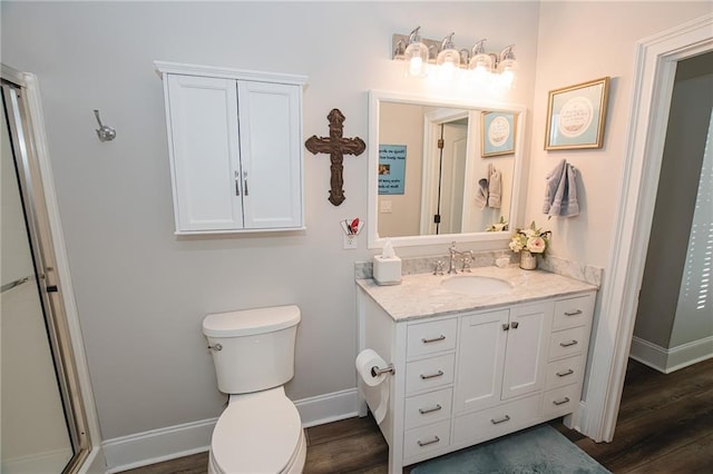 full bathroom with a shower with shower door, toilet, wood finished floors, baseboards, and vanity