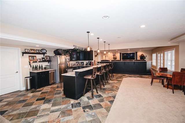 kitchen with a breakfast bar, recessed lighting, dark cabinets, and appliances with stainless steel finishes