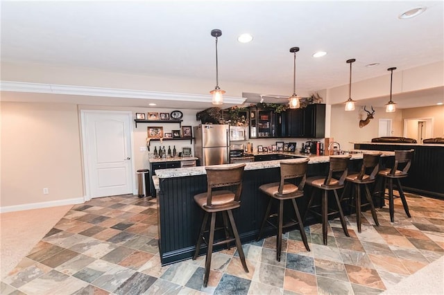 bar with recessed lighting, stainless steel appliances, indoor wet bar, baseboards, and hanging light fixtures