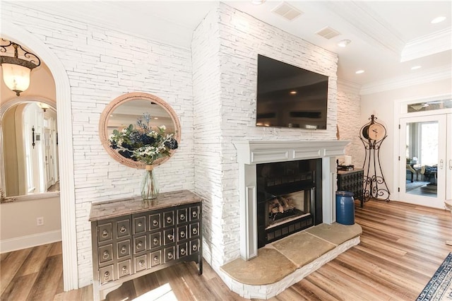 living area featuring recessed lighting, wood finished floors, visible vents, and ornamental molding