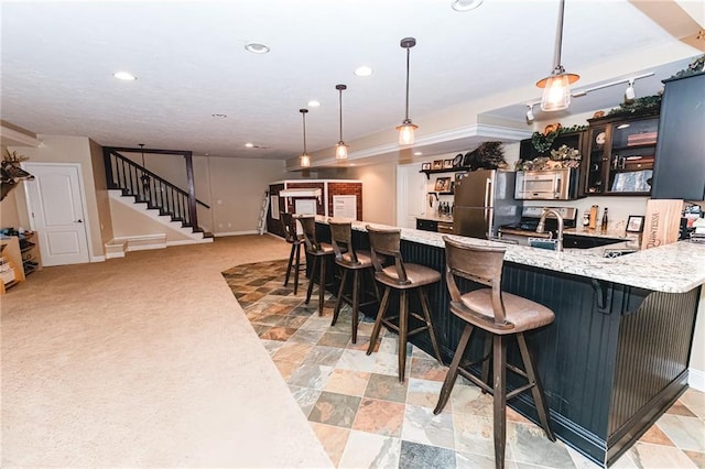 kitchen featuring a breakfast bar, a peninsula, recessed lighting, appliances with stainless steel finishes, and pendant lighting