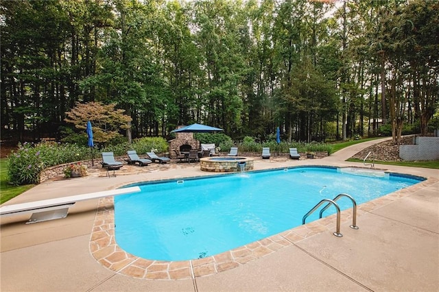 view of pool with a diving board, an outdoor fire pit, a pool with connected hot tub, and a patio area