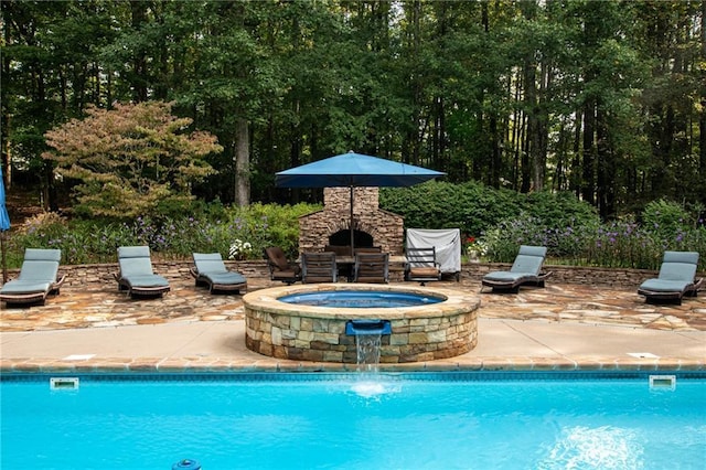 outdoor pool with an outdoor stone fireplace and a patio