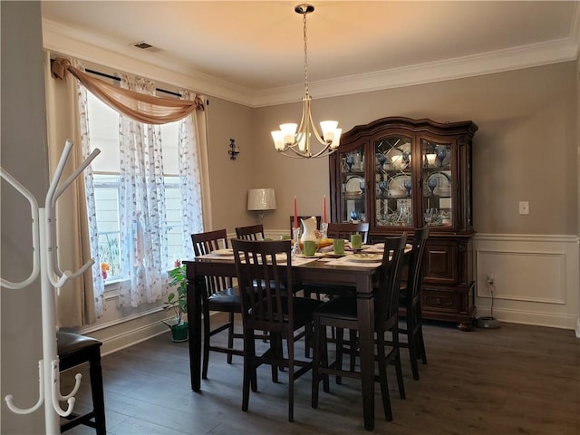 dining space featuring a wealth of natural light, dark hardwood / wood-style flooring, crown molding, and a chandelier