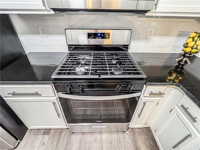 3150 Stratford Green Pl, Avondale Estates, GA 30002 - kitchen with stainless steel range with gas stovetop, dark countertops, wood finished floors, and tasteful backsplash