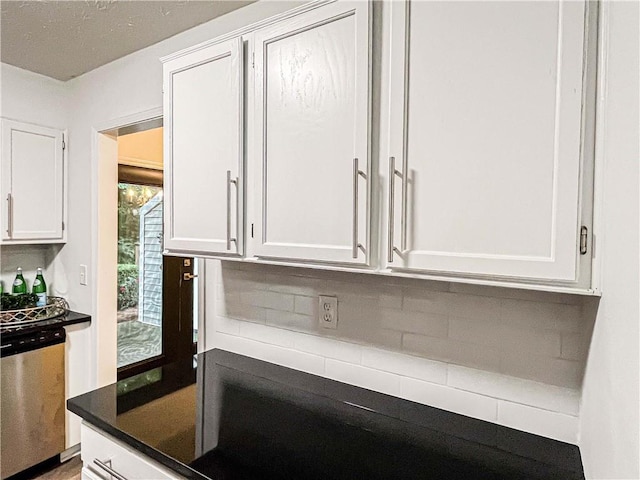 3150 Stratford Green Pl, Avondale Estates, GA 30002 - kitchen featuring stainless steel dishwasher, white cabinets, dark countertops, and decorative backsplash