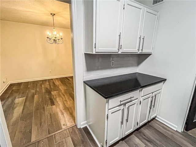 3150 Stratford Green Pl, Avondale Estates, GA 30002 - kitchen featuring dark countertops, dark wood finished floors, a chandelier, and white cabinets