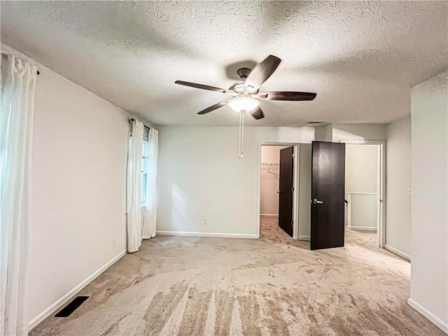 3150 Stratford Green Pl, Avondale Estates, GA 30002 - unfurnished bedroom with a textured ceiling, carpet flooring, a walk in closet, and ceiling fan