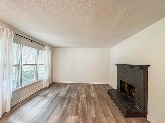 3150 Stratford Green Pl, Avondale Estates, GA 30002 - unfurnished living room with dark wood-style flooring, a brick fireplace, and a textured ceiling