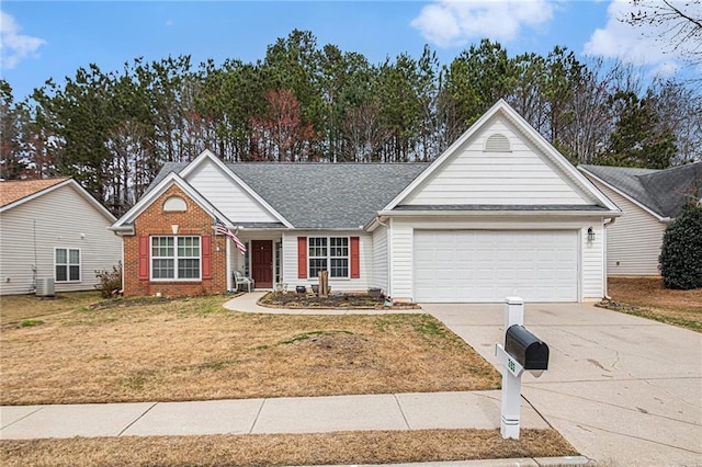 single story home with a shingled roof, concrete driveway, an attached garage, a front lawn, and brick siding