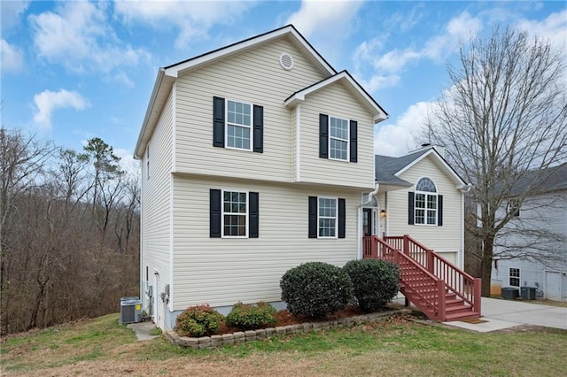 view of front of home with central AC and a front yard