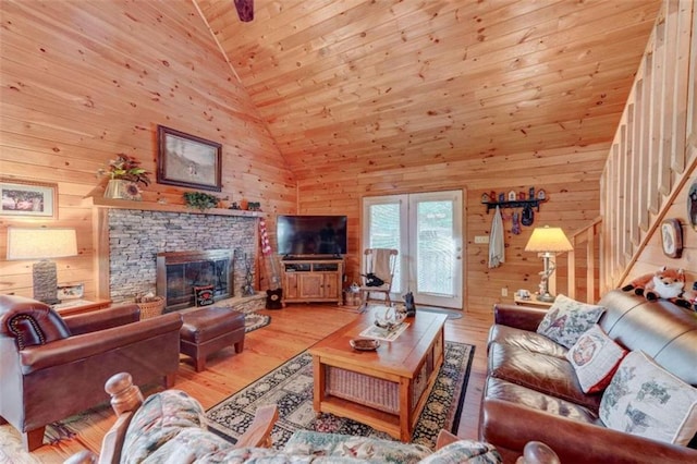 living room with high vaulted ceiling, a fireplace, wooden walls, hardwood / wood-style floors, and wood ceiling