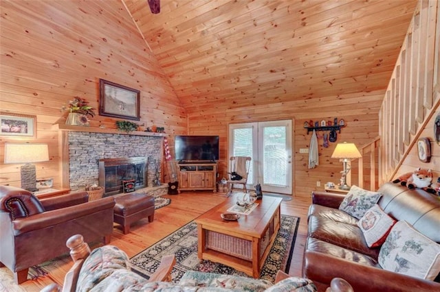 652 Fox Run Dr, Blue Ridge, GA 30513 - living area with wood walls, wood ceiling, a stone fireplace, light wood-type flooring, and high vaulted ceiling