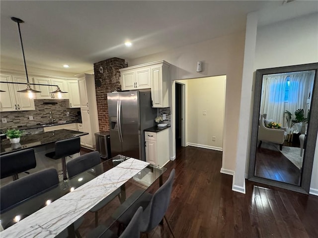 kitchen with dark hardwood / wood-style flooring, stainless steel fridge with ice dispenser, decorative light fixtures, and decorative backsplash