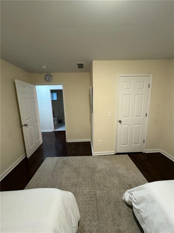 bedroom with dark hardwood / wood-style floors